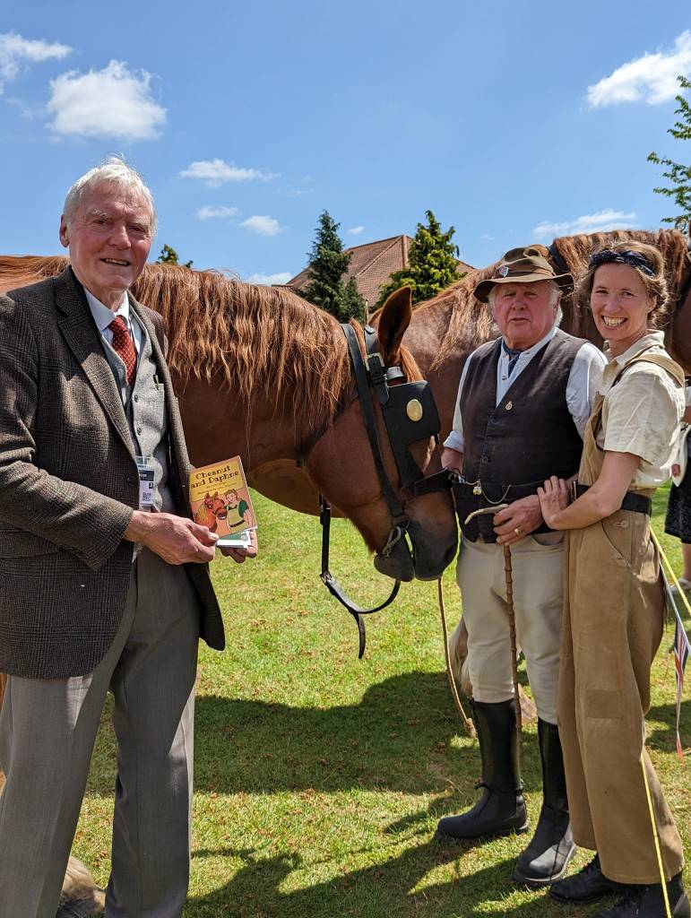 Suffolk Horse Society’s Former President, Nigel Oakley, stands with Holly Brega and John Thurman at the Rowley Mile Racecourse in Newmarket, 14th May 2022. Chesnut and Daphne Book launch.